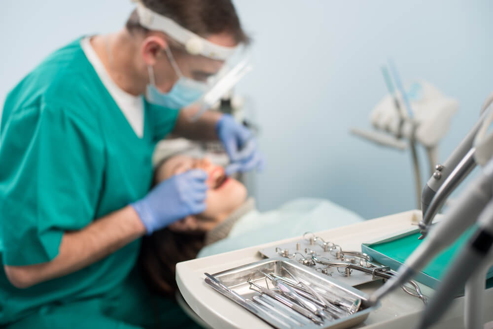 Dentist performing tooth extraction